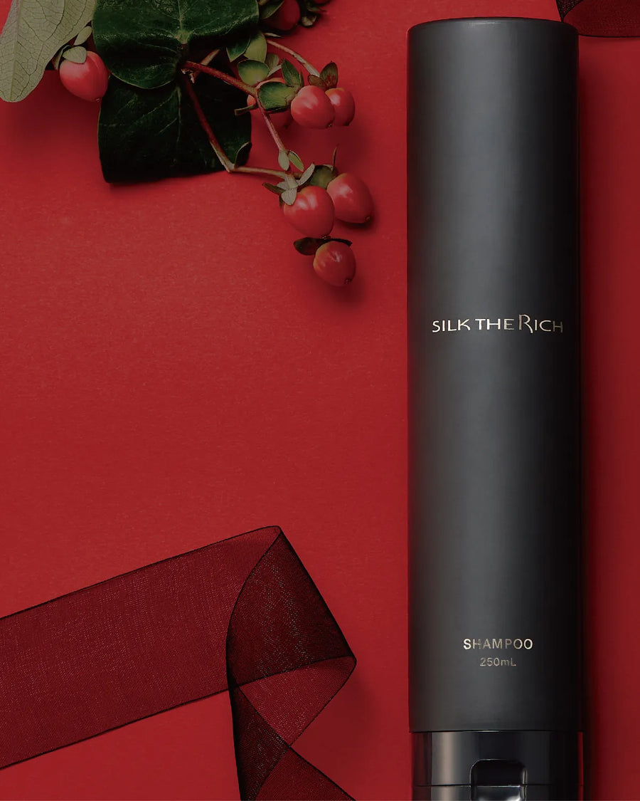 Black shampoo bottle with red berries and ribbon